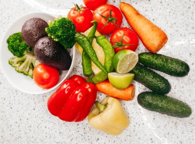 Sağlıklı yiyecekler beyaz masada taze sebzeler.