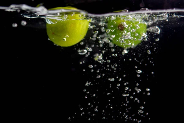Zielone Limonki Wodzie Czarnym Tle — Zdjęcie stockowe