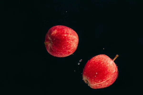 水の流れに赤いリンゴが２つ — ストック写真