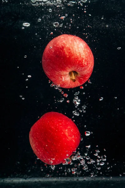 水の流れに赤いリンゴが２つ — ストック写真