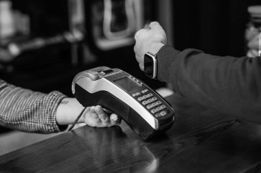 Elbise mağazasında akıllı saat uygulaması ile ödeme yapan adam, yakın plan, bakış açısı