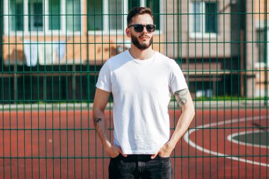 Şehirde beyaz tişörtlü, bel çantalı şık sakallı hippi.