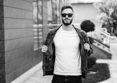 Beyaz tişörtlü ve gözlüklü, sakallı, şık bir genç. Sokak fotoğrafı