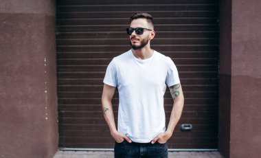 Beyaz tişörtlü ve gözlüklü, sakallı, şık bir genç. Sokak fotoğrafı