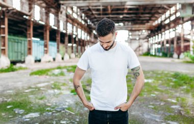 Beyaz tişörtlü ve gözlüklü, sakallı, şık bir genç. Sokak fotoğrafı