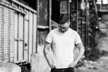 Beyaz tişörtlü ve gözlüklü, sakallı, şık bir genç. Sokak fotoğrafı