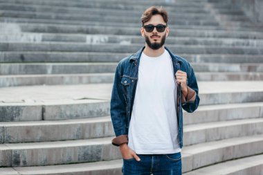 Beyaz tişörtlü ve gözlüklü, sakallı, şık bir genç. Sokak fotoğrafı