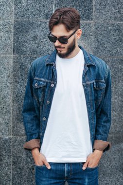 Beyaz tişörtlü ve gözlüklü, sakallı, şık bir genç. Sokak fotoğrafı