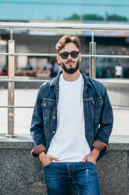 Beyaz tişörtlü ve gözlüklü, sakallı, şık bir genç. Sokak fotoğrafı