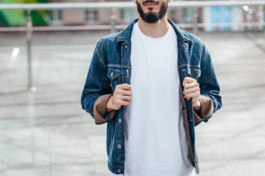 Beyaz tişörtlü ve gözlüklü, sakallı, şık bir genç. Sokak fotoğrafı