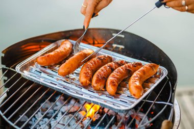Grilled sausage on the flaming grill, close up clipart