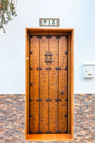 single wooden door with number thirteen on a wall