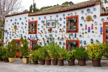 Granada, İspanya, 06 Nisan 2018:: cephe dekoratif seramik kaplamalar ve tarihi Albaicin Mahallesi'nde renkli çiçek dolu tencere ile geleneksel bir evin.