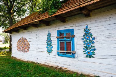 Zalipie, Polonya, 19 Ağustos 2018: Çiçekler ile renkli ev duvarları ve güneş saati Zalipie, Polonya köyü boyanmış. Dekoratif motifli evler boyama yerel bir gelenek için bilinen