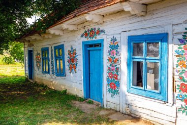 Zalipie, Polonya, 19 Ağustos 2018: Çiçekler ile renkli ev duvarları ve güneş saati Zalipie, Polonya köyü boyanmış. Dekoratif motifli evler boyama yerel bir gelenek için bilinen