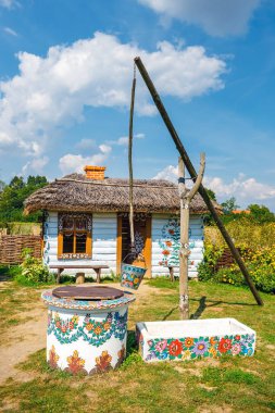 Zalipie, Polonya, 19 Ağustos 2018: Üzerinde renkli köyü - Zalipie, Polonya bir kuyuya bir kova. Dekoratif motifli evler boyama yerel bir gelenek için bilinen