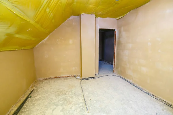 Empty room in a house under construction with fresh screed and plaster — Stock Photo, Image
