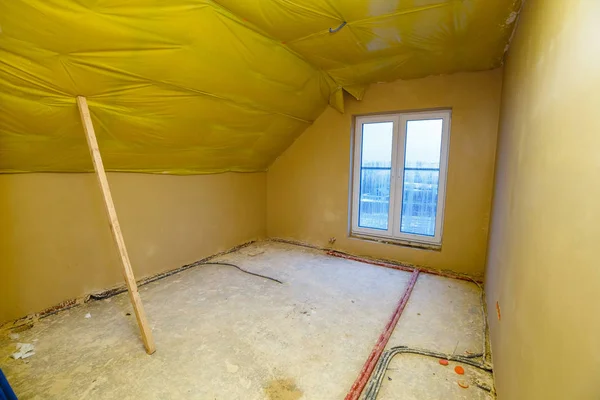 Empty room in a house under construction with fresh screed and plaster — Stock Photo, Image