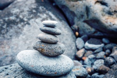 deniz kıyısında pürüzsüz taşlar katlanmış piramit, zen taşı, denge ve meditasyon sembolü