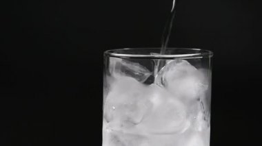 Cam bardak buz ve su siyah arka plan üzerine.