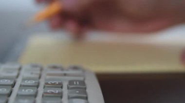 Bir adam notes ile hesap makinesi kullanma.