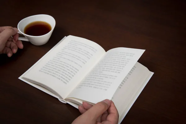 Man Hand Lezen Met Een Kopje Koffie Één Hand — Stockfoto