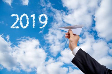 Kağıt Uçak gökyüzü arka plan üzerinde tutan işadamı el.