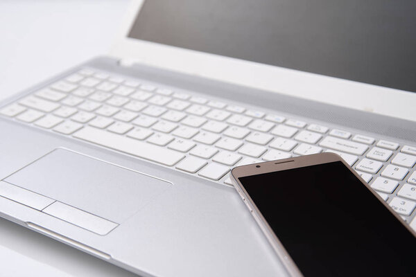 Клавиатура смартфона и ноутбука на белом фоне
.