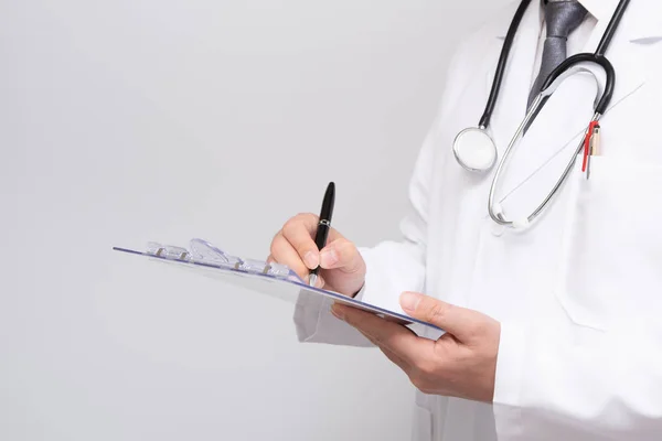 Close-up de médicos mãos escrevendo no prontuário . — Fotografia de Stock