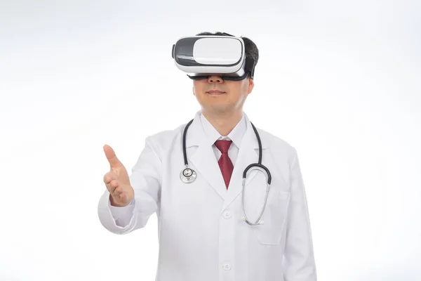 Médico masculino vestindo óculos de realidade virtual isolado no fundo branco . — Fotografia de Stock