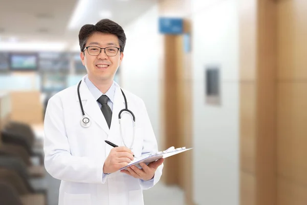 Asiático médico masculino sorrindo no fundo do hospital — Fotografia de Stock