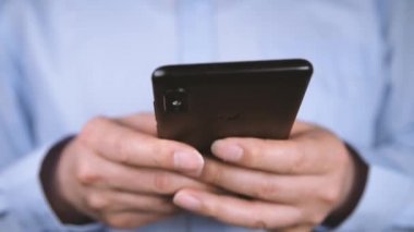 Akıllı telefon kullanarak işadamı ellerini yakın çekim.