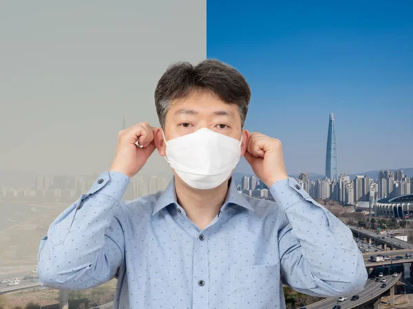 Мужчина средних лет в маске на фоне города, полного пыли . — стоковое фото