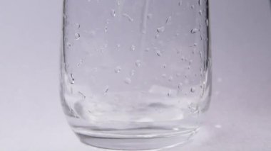 Beyaz arka planda cam bardak içine su dökme.