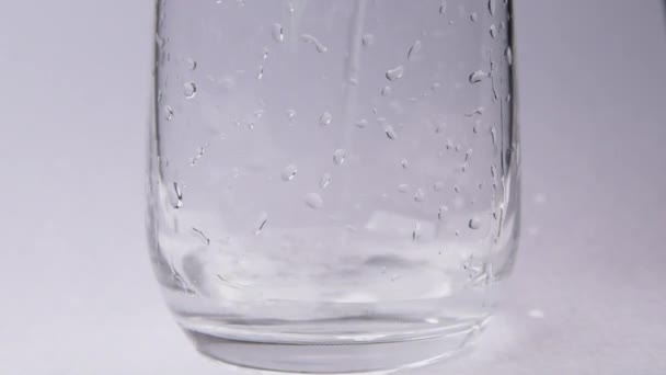 Verter Agua Una Taza Vidrio Sobre Fondo Blanco — Vídeo de stock