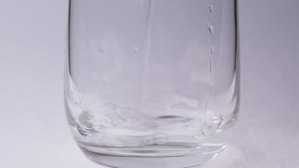 Verser Eau Dans Une Tasse Verre Sur Fond Blanc — Video