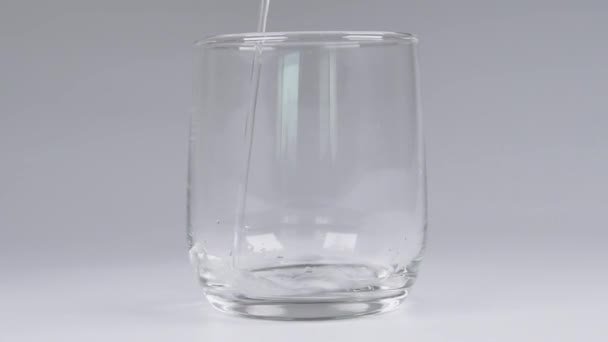 Gießen Von Wasser Eine Glasschale Über Weißem Hintergrund — Stockvideo