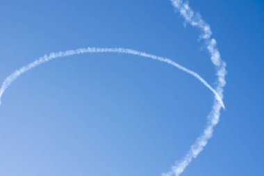 Airplane trails on blue sky with copy space. clipart