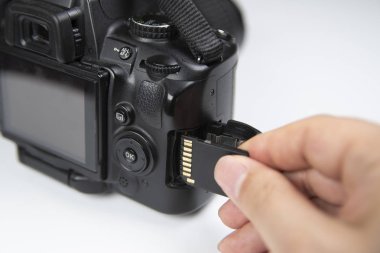 Sd bellek kartı ekleme Dslr kamera tutan fotoğrafçı el.