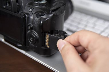 Sd bellek kartı ekleme Dslr kamera tutan fotoğrafçı el.