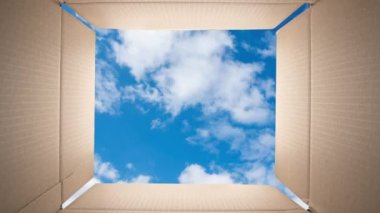 Bulutlar bir karton kutunun içinden mavi gökyüzünde hızla hareket ediyor. Zaman Uygulaması.