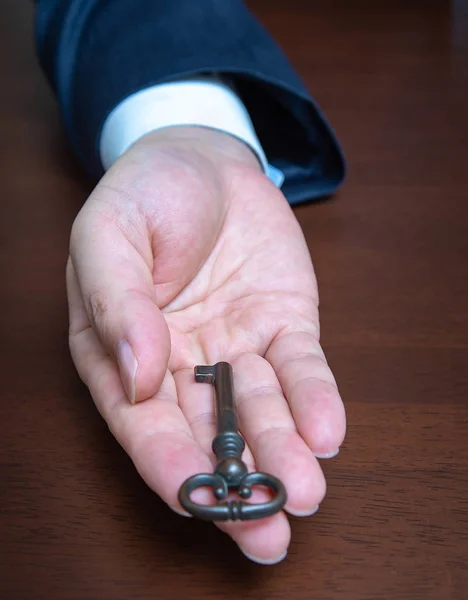 Επιχειρηματίας κρατώντας το παλιό κλειδί. Επιχειρηματικές έννοιες — Φωτογραφία Αρχείου