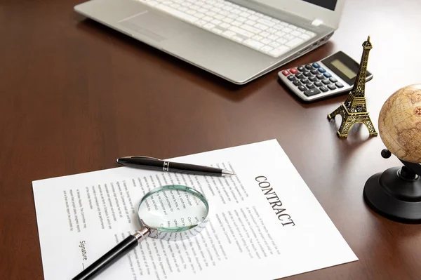 Contract documents and magnifiers on a businessmans desk