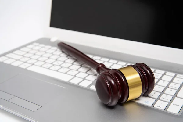Ξύλινος δικαστής σφυράκι σε ασημένιο φορητό υπολογιστή, νόμο περί κυβερνονόμου ή διαδικτυακή δημοπρασία. — Φωτογραφία Αρχείου