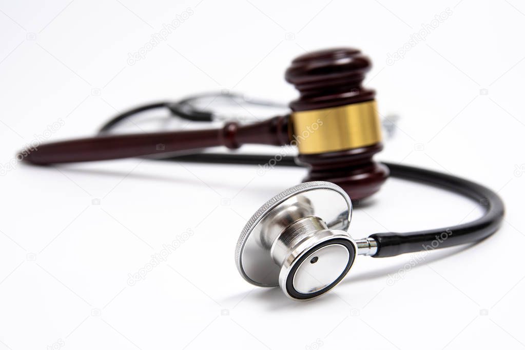 A wooden judge gavel and stethoscope isolated on white background. Medical dispute concept.