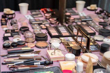 Profesyonel bir makyaj sanatçısının çalışma masasında çeşitli kozmetik ürünler var..