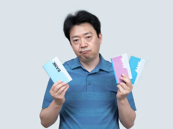 灰色の背景に彼の手に銀行券を保持している中年のアジア人男性 — ストック写真