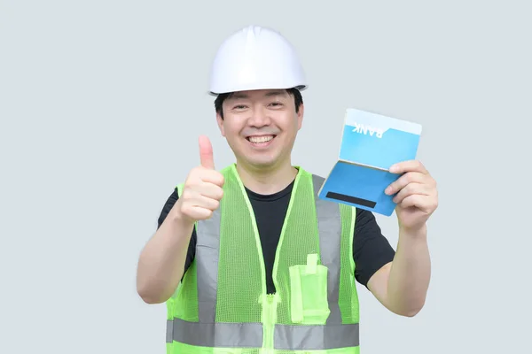 灰色の背景に彼の手に銀行のパスワードブックを保持している中年のアジアのエンジニア — ストック写真