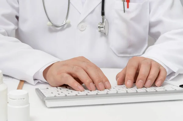 Mani di un medico maschio che utilizza una tastiera del computer . — Foto Stock