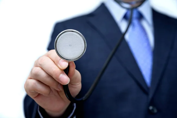 Uomo d'affari che tiene in mano uno stetoscopio . — Foto Stock